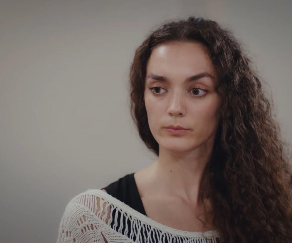 Maryam z długimi, kręconymi włosami i w białym swetrze, spogląda w bok. Zmiana wyglądu Nany (Maryam) w 880. odcinku serialu Dziedzictwo, gdzie Poyraz ujrzy ją w zupełnie nowym świetle. O tych i innych wydarzeniach w tureckich telenowelach przeczytasz na stronie Super Seriale.