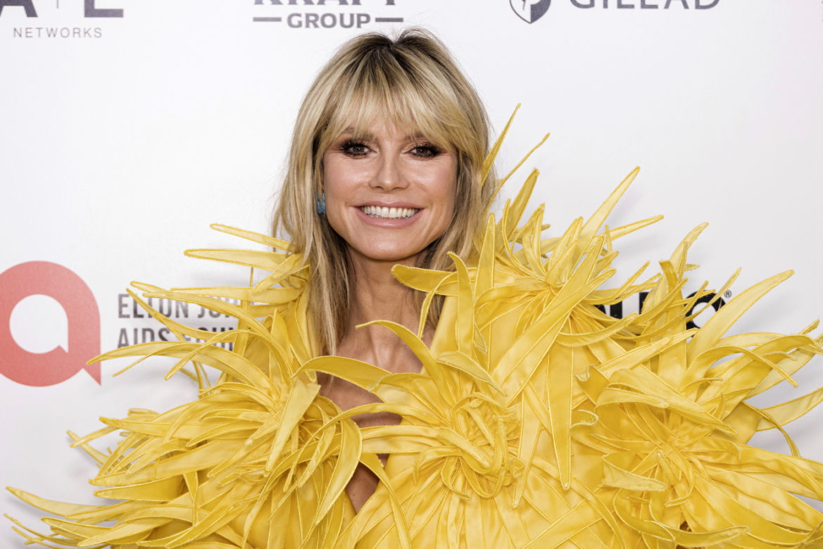 Heidi Klum półnago wygina się na trawie. Ma futrzaną czapę i kuse bikini. Co się dzieje z jej biustem?!