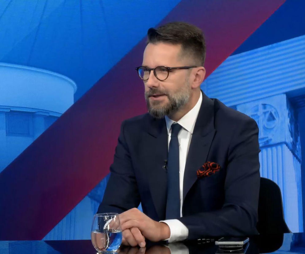 Radosław Fogiel w okularach i garniturze siedzi przy stole w studio. O jego wypowiedzi w RMF FM przeczytasz na SE Polityka.
