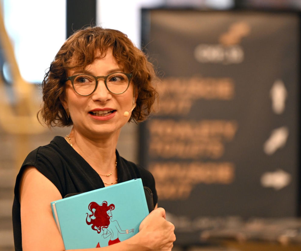 Daria Gosek-Popiołek w okularach trzyma niebieską książkę. O kandydatce na prezydenta Krakowa przeczytasz na SE Polityka.
