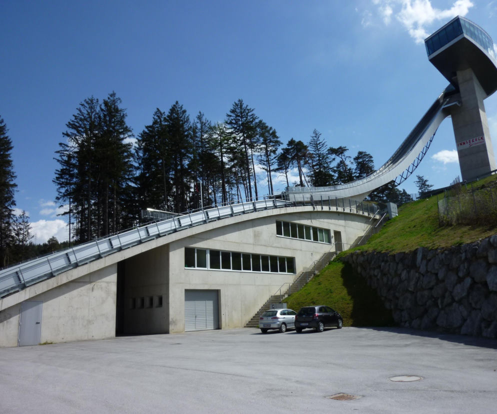 Futurystyczna skocznia narciarska Bergisel w Innsbrucku projektu Zahy Hadid z wieżą najazdową i budynkiem głównym z betonu i stali, wkomponowana w zalesione wzgórze. Ten przykład architektonicznej wizji znajdziesz na Architektura Murator Plus.